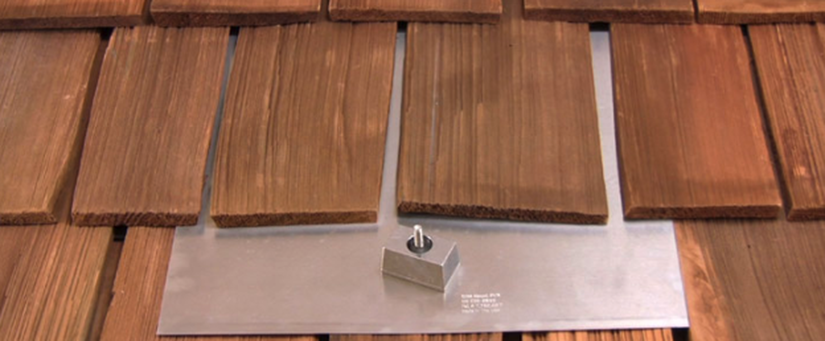 Close up view of a flashing piece mounted on a wooden tile roof